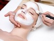 Beschreibung: Woman receiving facial mask at beauty salon