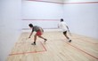 Beschreibung: Squash players in action on a squash court (motion blurred image